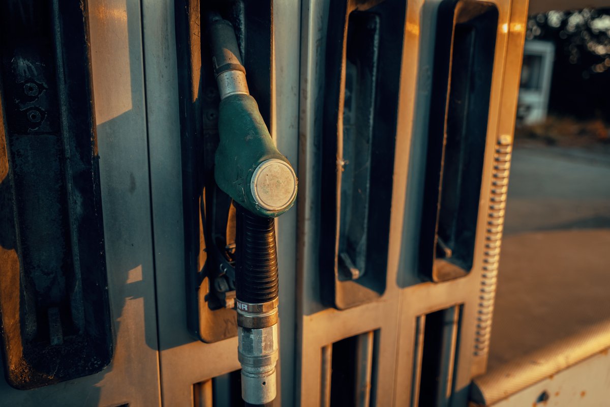 Zapfpistole an einer Tankstelle bei Sonnenuntergang