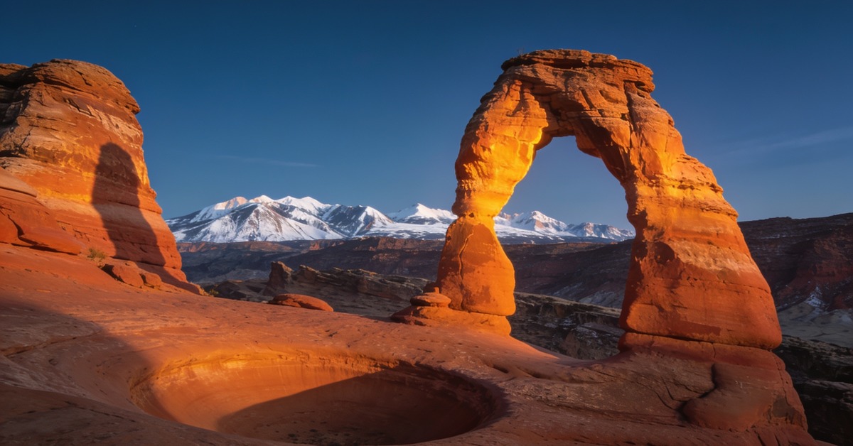 Arches Nationalpark: der Delicate Arch bei Sonnenuntergang mit den La-Sal-Bergen in Utah